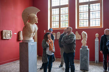 Andreas Dracopoulos, the co-president of the Stavros Niarchos Foundation, and other Stavros Niarchos Foundation members admire a statue at the Archaeological Museum of Sparta
